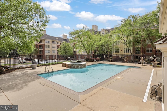 community pool featuring a patio area, a hot tub, and fence