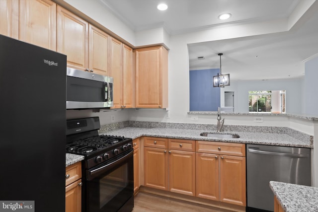 kitchen featuring black appliances, ornamental molding, light stone countertops, and a sink