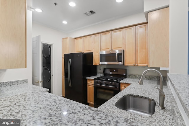 kitchen featuring light brown cabinetry, a sink, visible vents, black appliances, and light stone counters