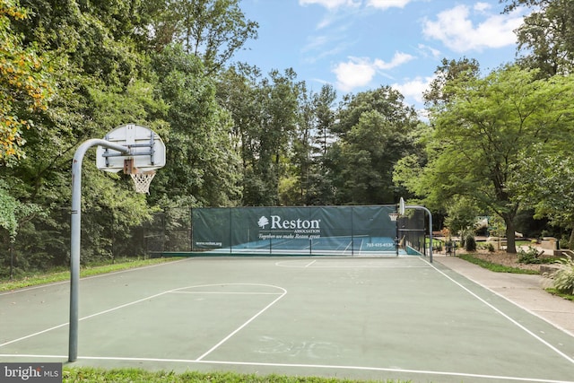 view of basketball court featuring a tennis court, fence, and community basketball court