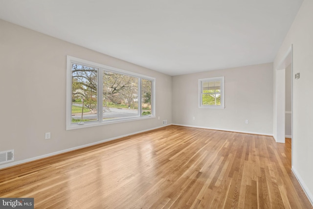 spare room featuring visible vents, baseboards, and light wood-style floors