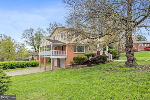 view of front of property with a front yard, brick siding, a garage, and driveway