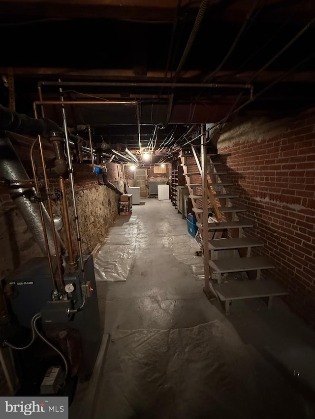 unfinished basement featuring a heating unit and washer / dryer