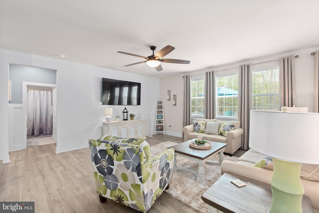 living area with a ceiling fan and wood finished floors