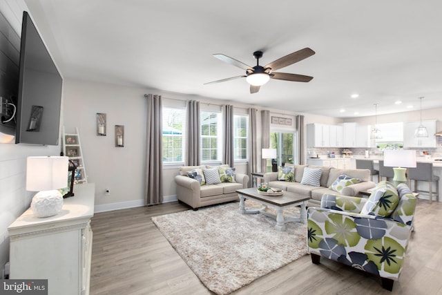 living room with recessed lighting, plenty of natural light, and light wood-type flooring