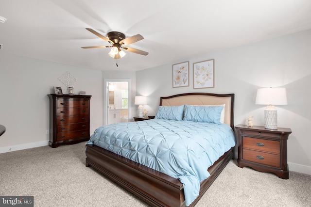 bedroom with carpet floors, a ceiling fan, baseboards, and ensuite bathroom