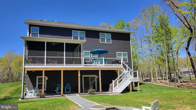 rear view of house featuring a lawn, a wooden deck, a sunroom, and stairway