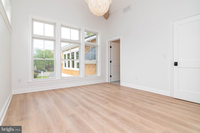 816 Garfield Pkwy, Bethany Beach, DE 19930 - unfurnished room featuring a chandelier, light wood-style flooring, and baseboards