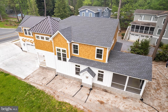 816 Garfield Pkwy, Bethany Beach, DE 19930 - back of house with a sunroom, a shingled roof, a standing seam roof, and metal roof