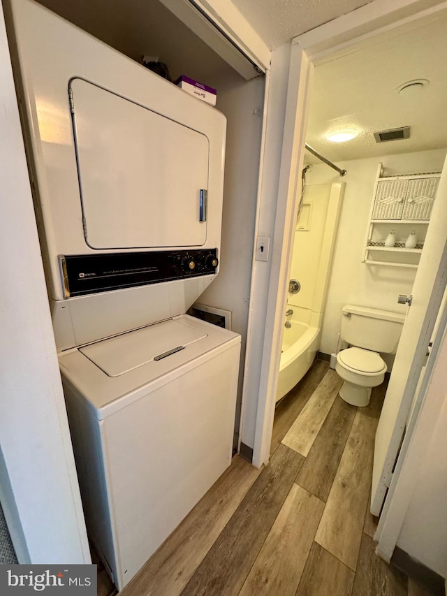 9900 Coastal Hwy Unit 413, Ocean City, MD 21842 - clothes washing area with stacked washing machine and dryer and wood finished floors