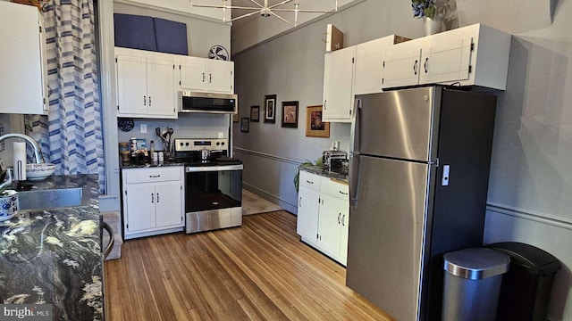 124 W Church St, Frederick, MD 21701 - kitchen featuring wood finished floors, white cabinets, a sink, and appliances with stainless steel finishes