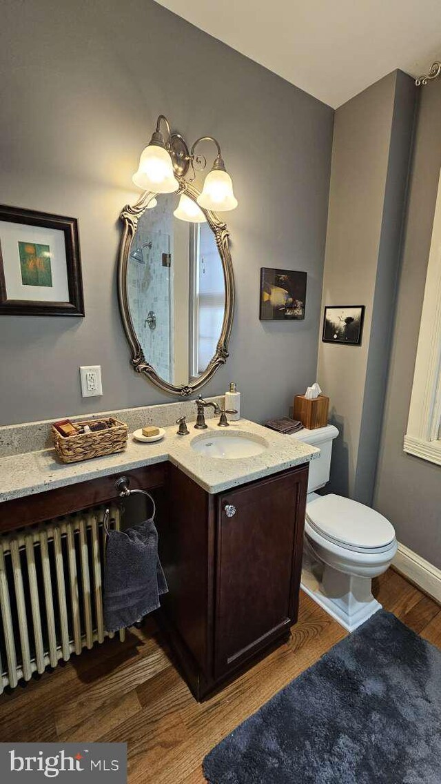 124 W Church St, Frederick, MD 21701 - half bathroom featuring toilet, vanity, radiator, and wood finished floors