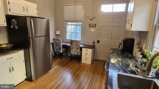 124 W Church St, Frederick, MD 21701 - kitchen with light wood-type flooring, freestanding refrigerator, dark countertops, white cabinets, and a sink
