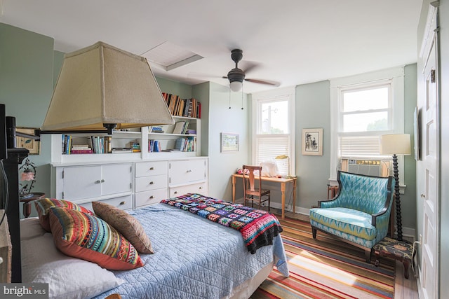 bedroom with wood finished floors, cooling unit, and baseboards