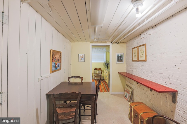 dining area with light floors and wood walls