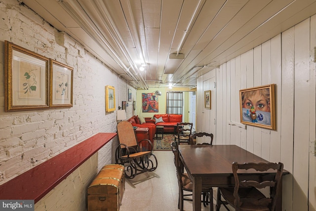 dining area featuring brick wall