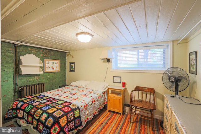 bedroom with radiator, wood ceiling, and brick wall