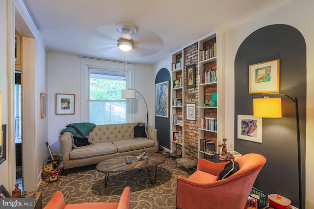 living area featuring ornamental molding, built in features, and ceiling fan