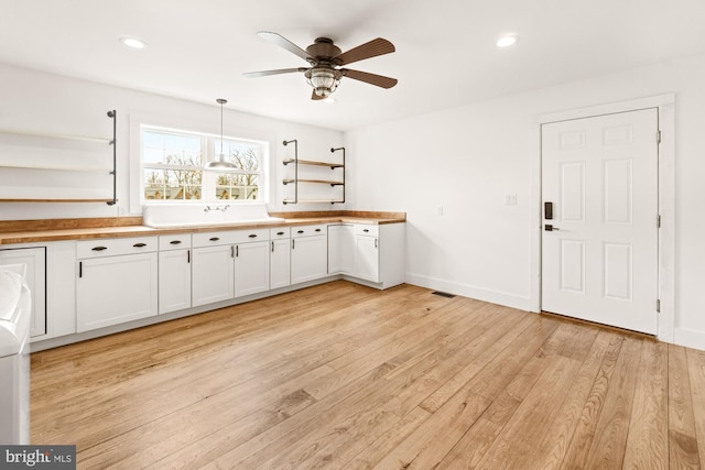 kitchen with open shelves, light wood-style flooring, a ceiling fan, and white cabinetry