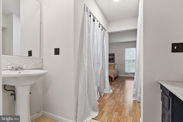 full bath with wood finished floors and baseboards