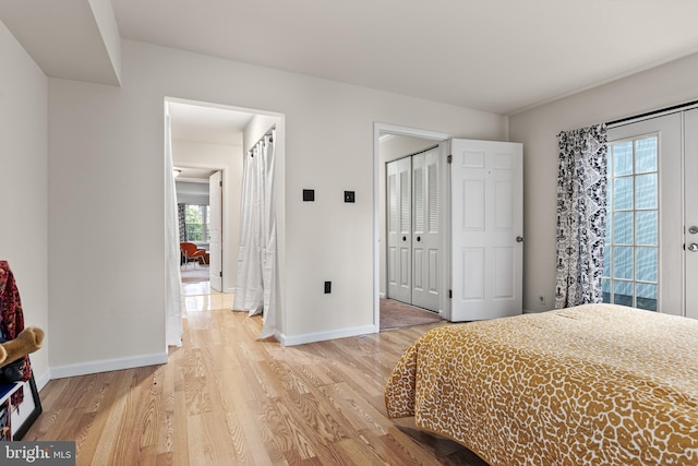bedroom with light wood finished floors, baseboards, and a closet