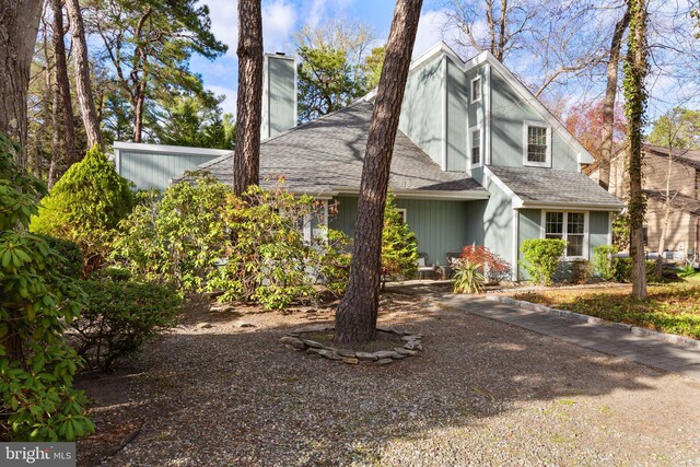 view of front of property featuring a shingled roof and a chimney