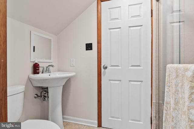 bathroom featuring lofted ceiling, toilet, walk in shower, and tile patterned floors
