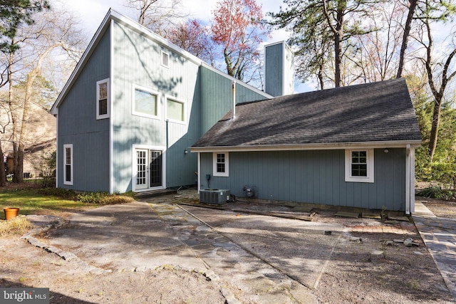 rear view of house featuring central AC, roof with shingles, and french doors