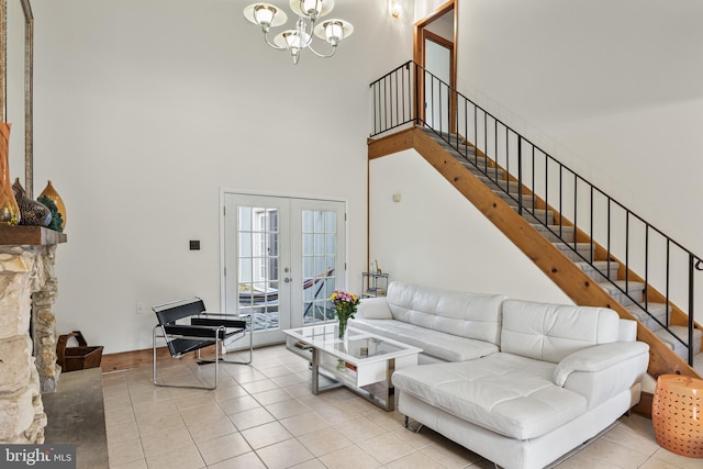 living room with a chandelier, a towering ceiling, tile patterned flooring, and stairs
