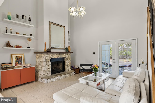 living room with a high ceiling, a fireplace, a chandelier, and light tile patterned flooring
