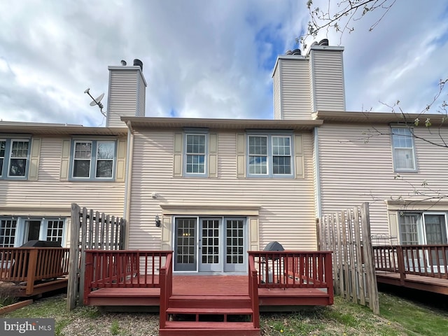 back of house featuring a chimney and a deck