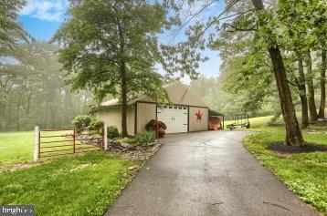 20 Tower Rd, Dillsburg, PA 17019 - view of front facade with an outbuilding, asphalt driveway, a front yard, and a detached garage