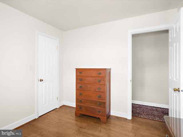 bedroom with baseboards and wood finished floors