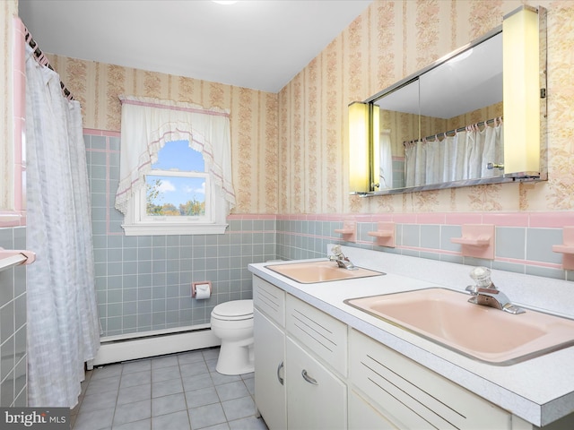 bathroom featuring a sink, tile patterned flooring, baseboard heating, and wallpapered walls