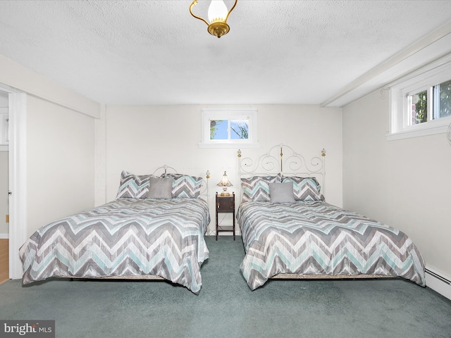 carpeted bedroom with baseboard heating and a textured ceiling