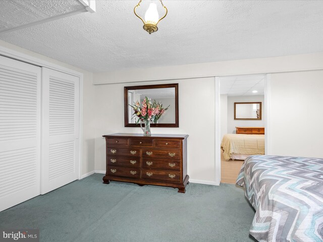 bedroom featuring carpet floors, a textured ceiling, and a closet
