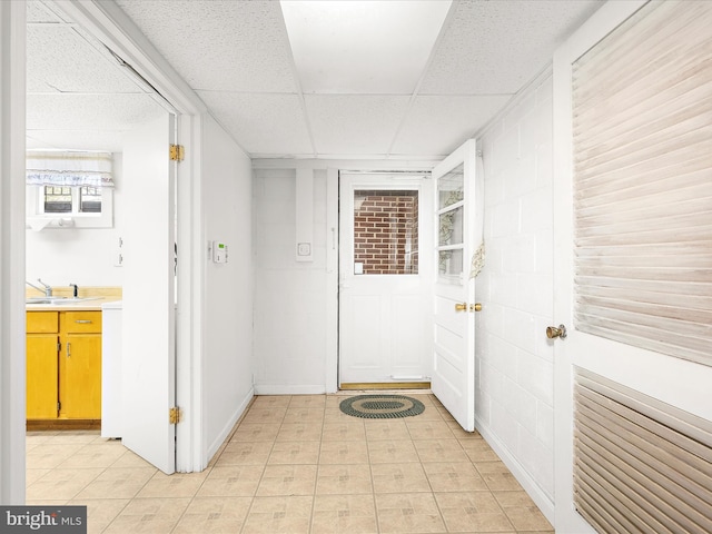 hall featuring a paneled ceiling and a sink