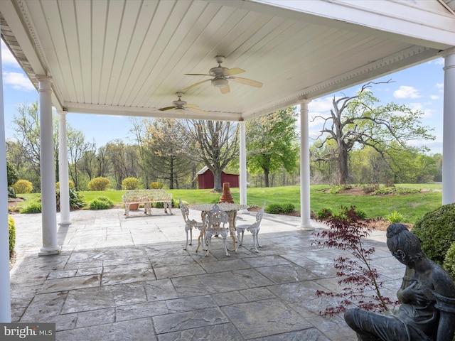 view of patio with an outdoor structure, a ceiling fan, outdoor dining area, and a storage shed