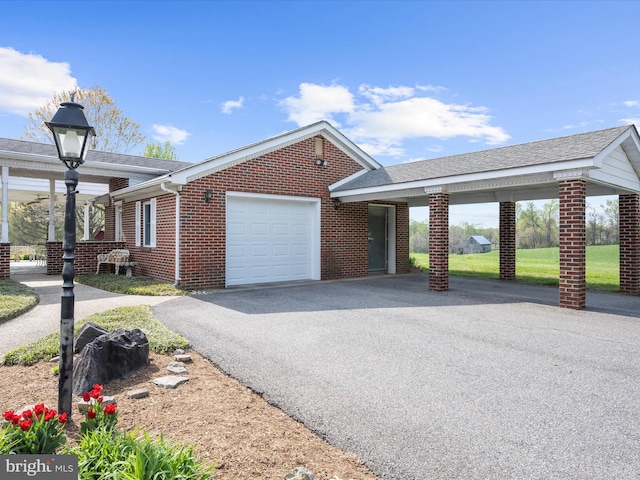 view of front of property featuring brick siding, an attached garage, and driveway