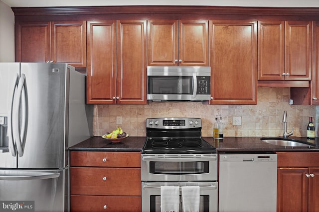 3275 Sutton Pl NW Unit A, Washington, DC 20016 - kitchen with appliances with stainless steel finishes, a sink, backsplash, brown cabinetry, and dark stone countertops