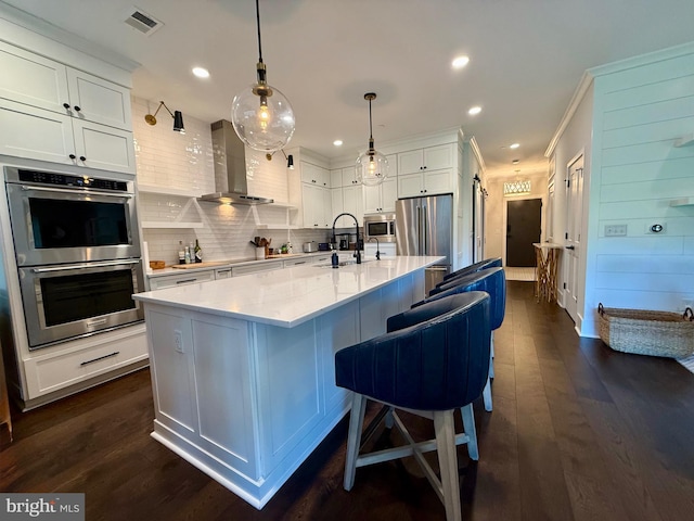 141 W St Unit 304, Annapolis, MD 21401 - kitchen featuring stainless steel appliances, wall chimney exhaust hood, white cabinetry, tasteful backsplash, and a sink