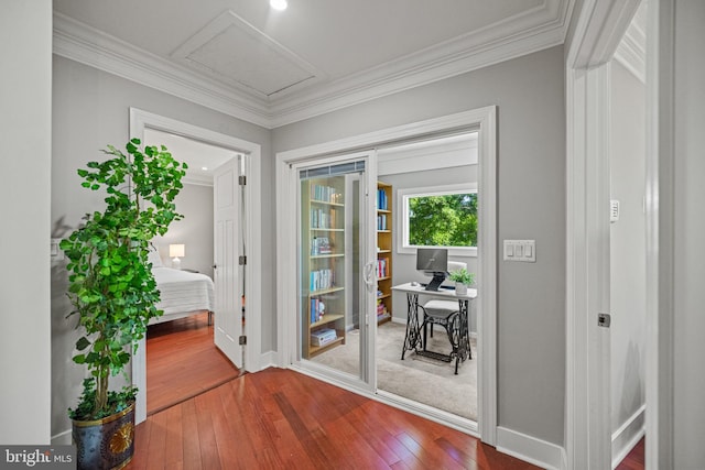 entryway with crown molding, baseboards, and hardwood / wood-style flooring