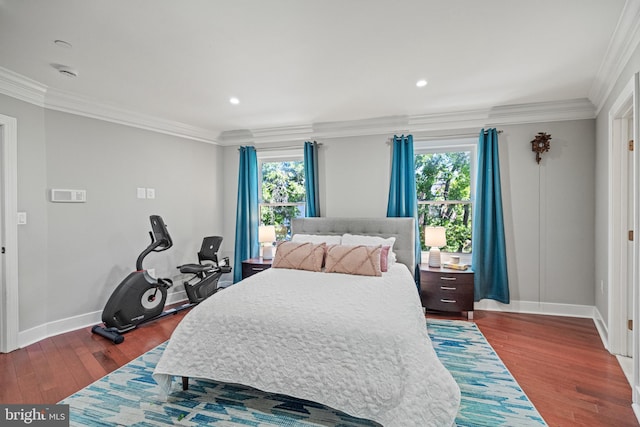 bedroom featuring crown molding, baseboards, multiple windows, and wood finished floors