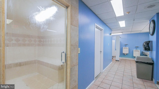 full bath featuring baseboards, tile patterned flooring, a stall shower, and a drop ceiling