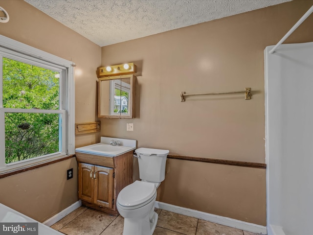bathroom featuring a healthy amount of sunlight, vanity, tile patterned flooring, and baseboards