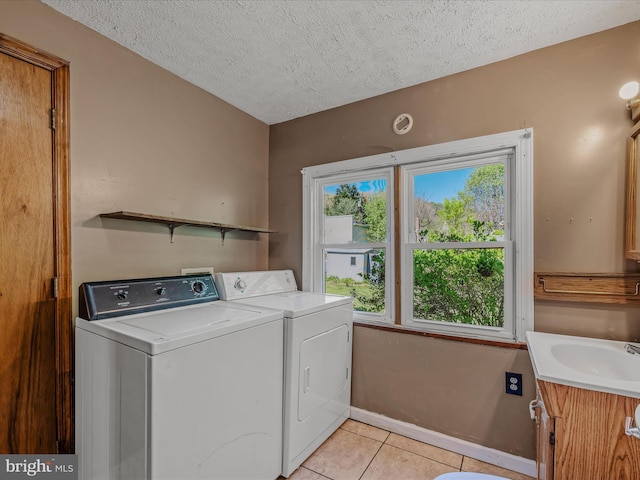 laundry area with a textured ceiling, cabinet space, and washing machine and dryer