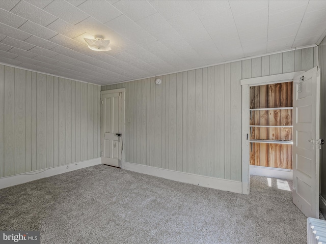 empty room with wooden walls and carpet