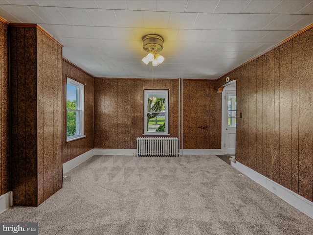 unfurnished room with plenty of natural light, carpet, ceiling fan, and radiator heating unit