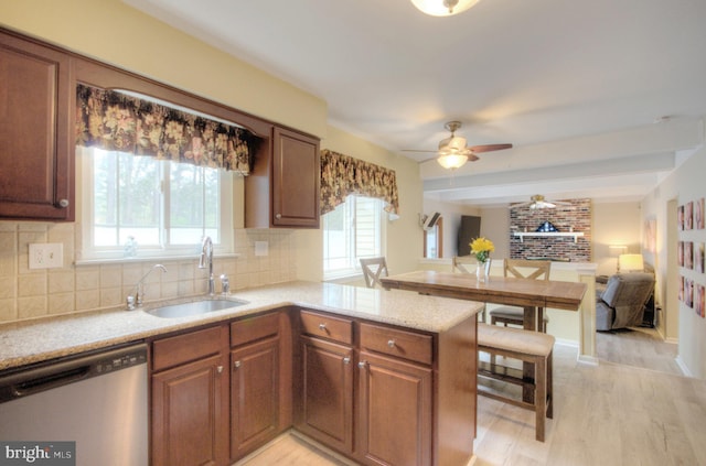 kitchen featuring a sink, dishwasher, a ceiling fan, open floor plan, and tasteful backsplash