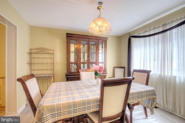 dining area featuring light wood-type flooring and a notable chandelier